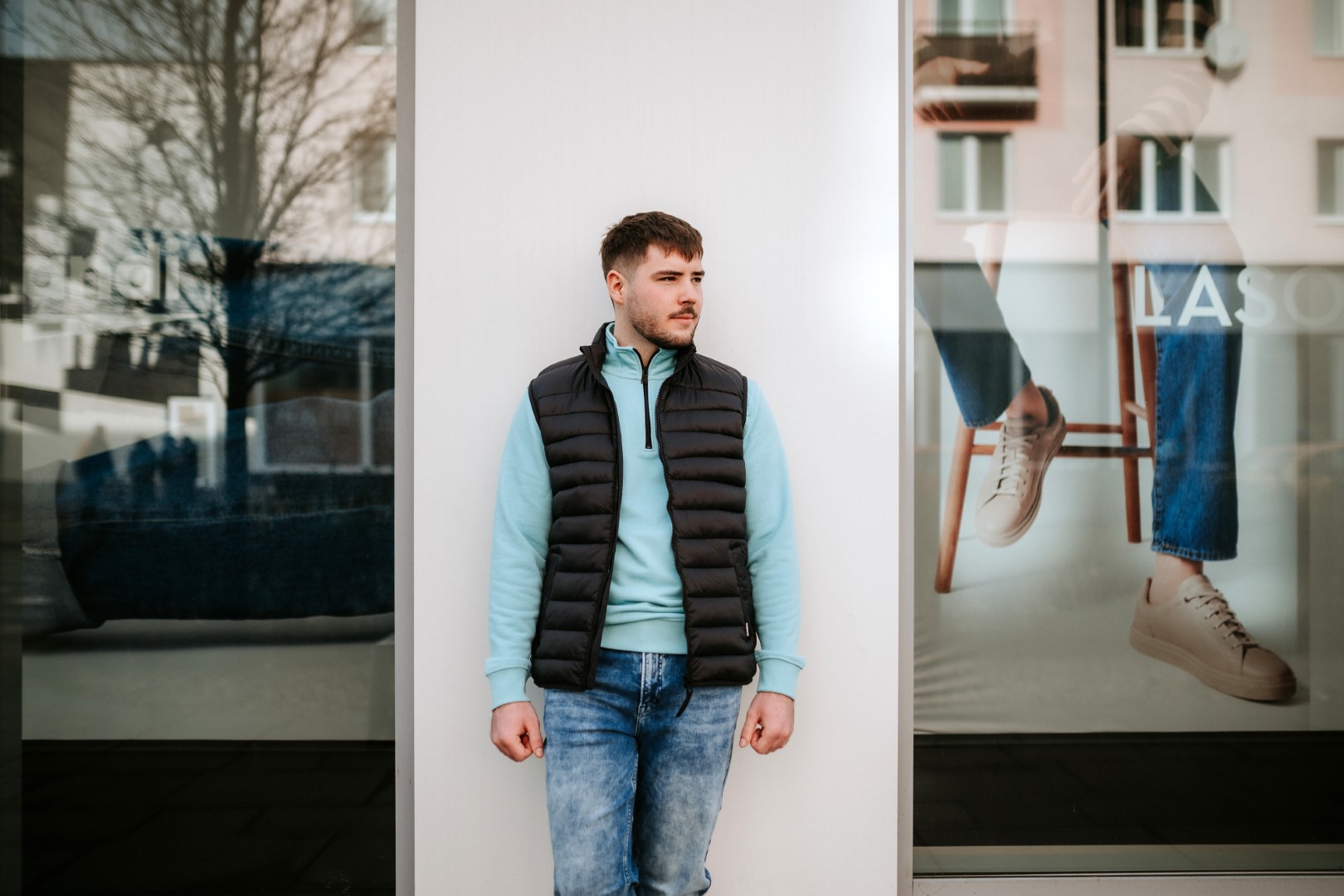 muz v modrej mikine a tmavohnedej veste